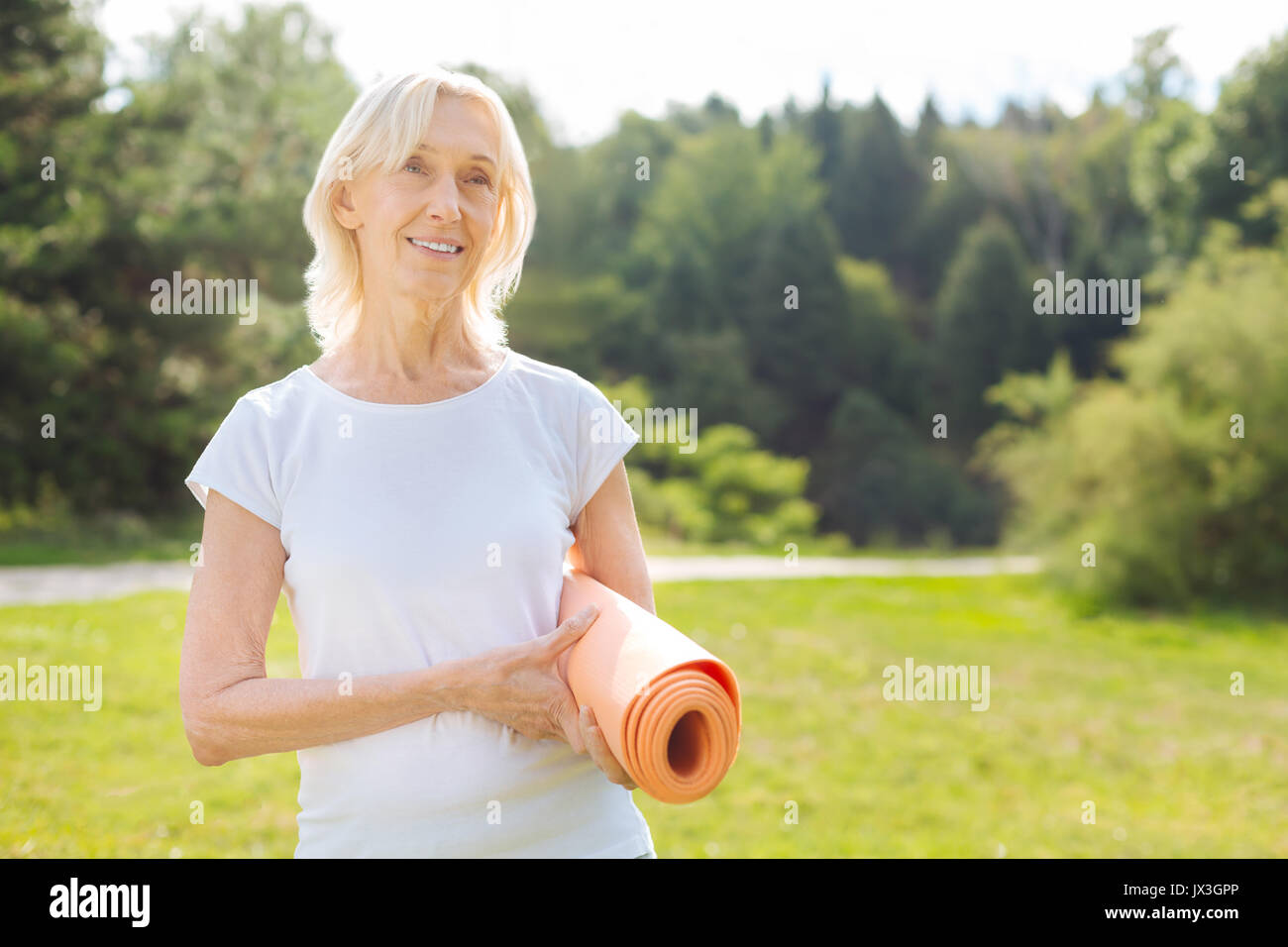 Positiv erfreut ältere Frau ihre matte Holding Stockfoto Positiv erfreut ältere Frau ihre matte Holding Stockfoto