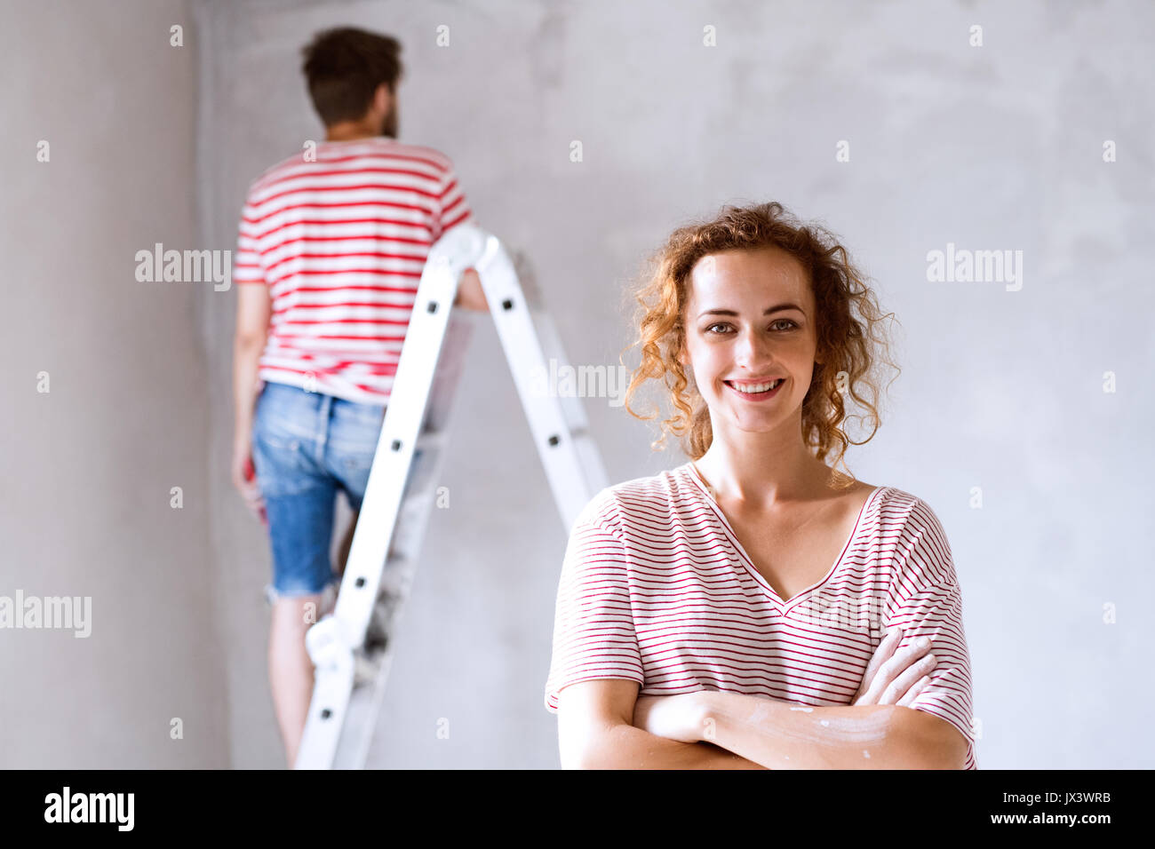 Schöne junge Paar Malerei Wände in Ihrem neuen Haus mit Pinsel. Home Makeover und Sanierungskonzept. Stockfoto