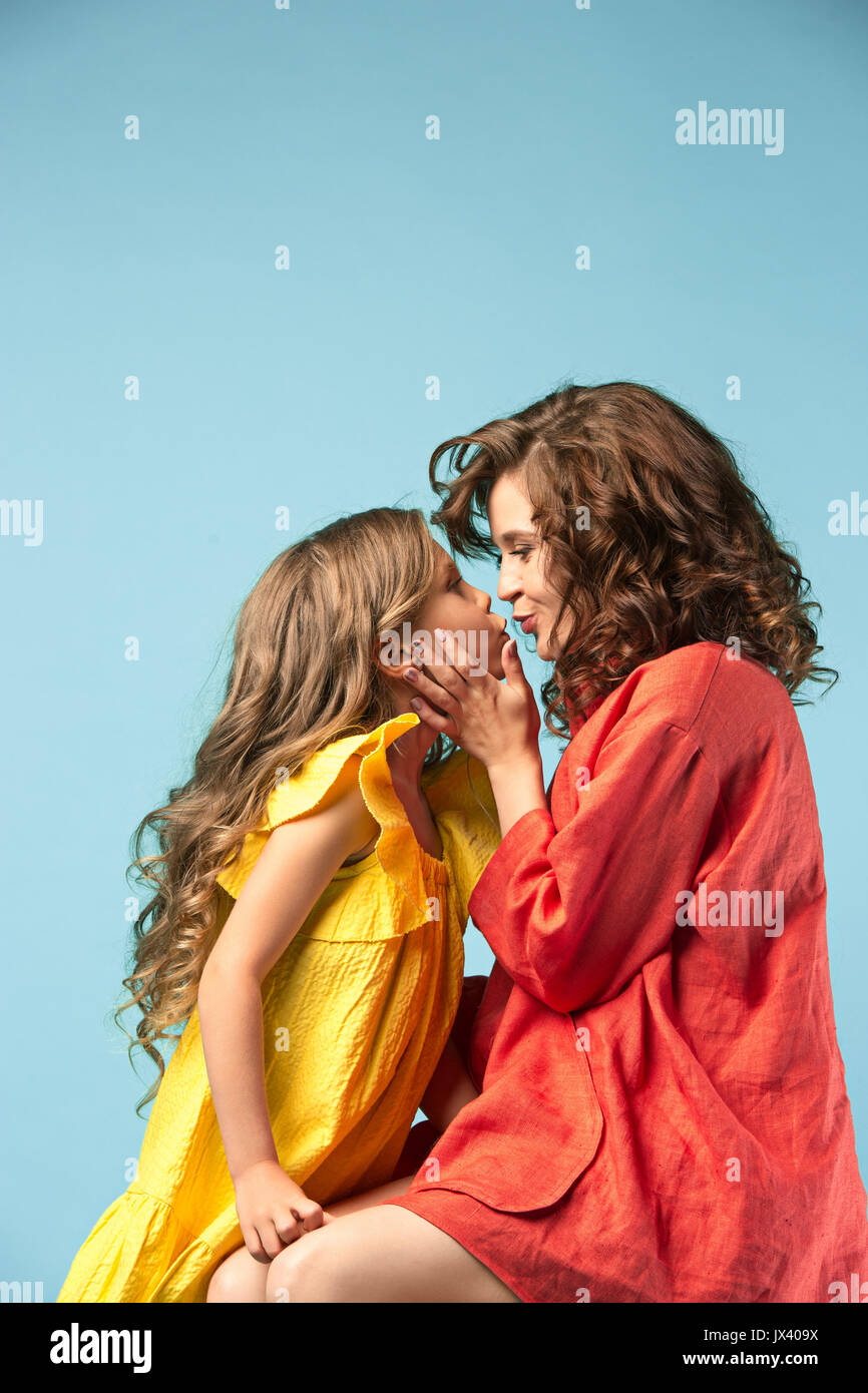 Schwangere Mutter mit jugendlich Tochter. Familie Studio Portrait über blauer Hintergrund Stockfoto