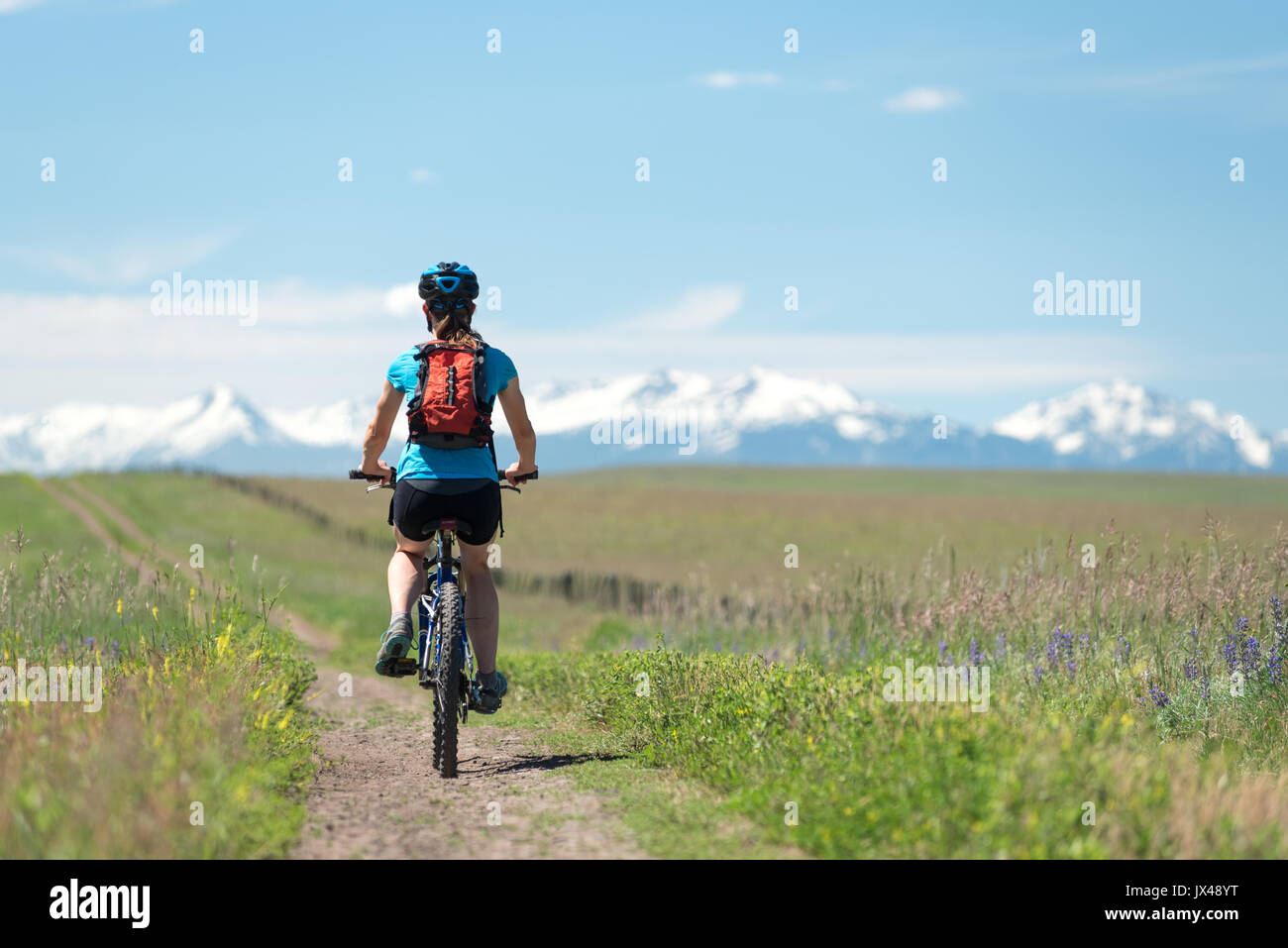 Frauen Mountainbike eine Straße auf der Zumwalt Prairie im Nordosten von Oregon. Stockfoto