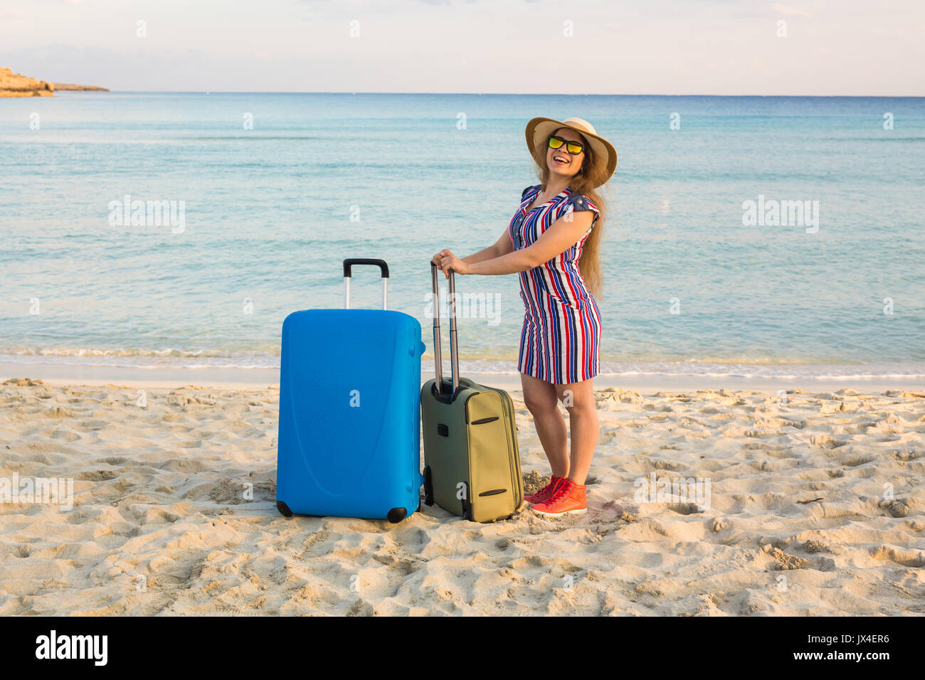 Schöne junge Dame mit einem blauen Koffer am Strand. Menschen, Reisen,  Ferien und Sommer Konzept Stockfotografie - Alamy