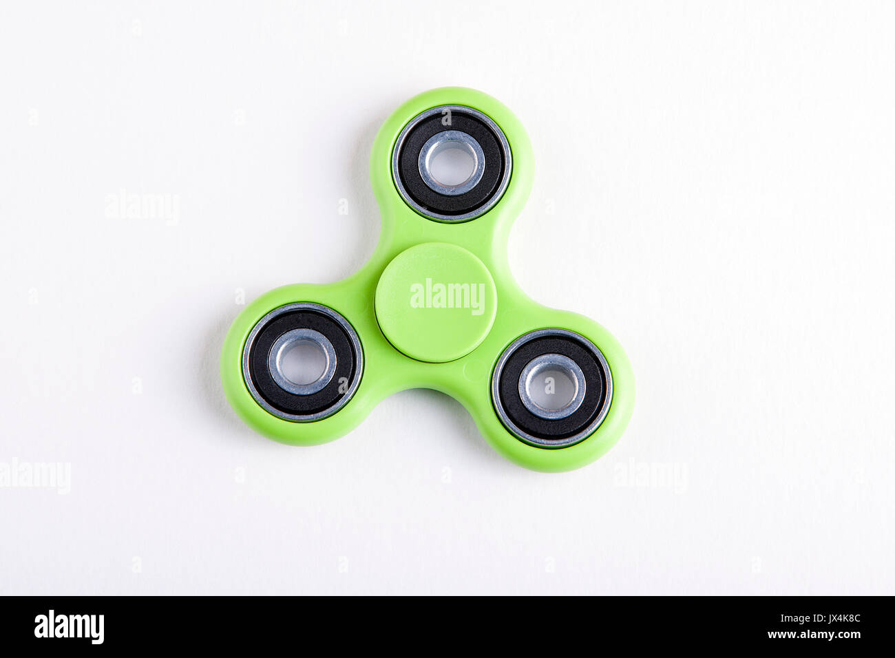 Green fidget Spinner Spannungsarmglühen Spielzeug auf weißem Hintergrund. Stockfoto
