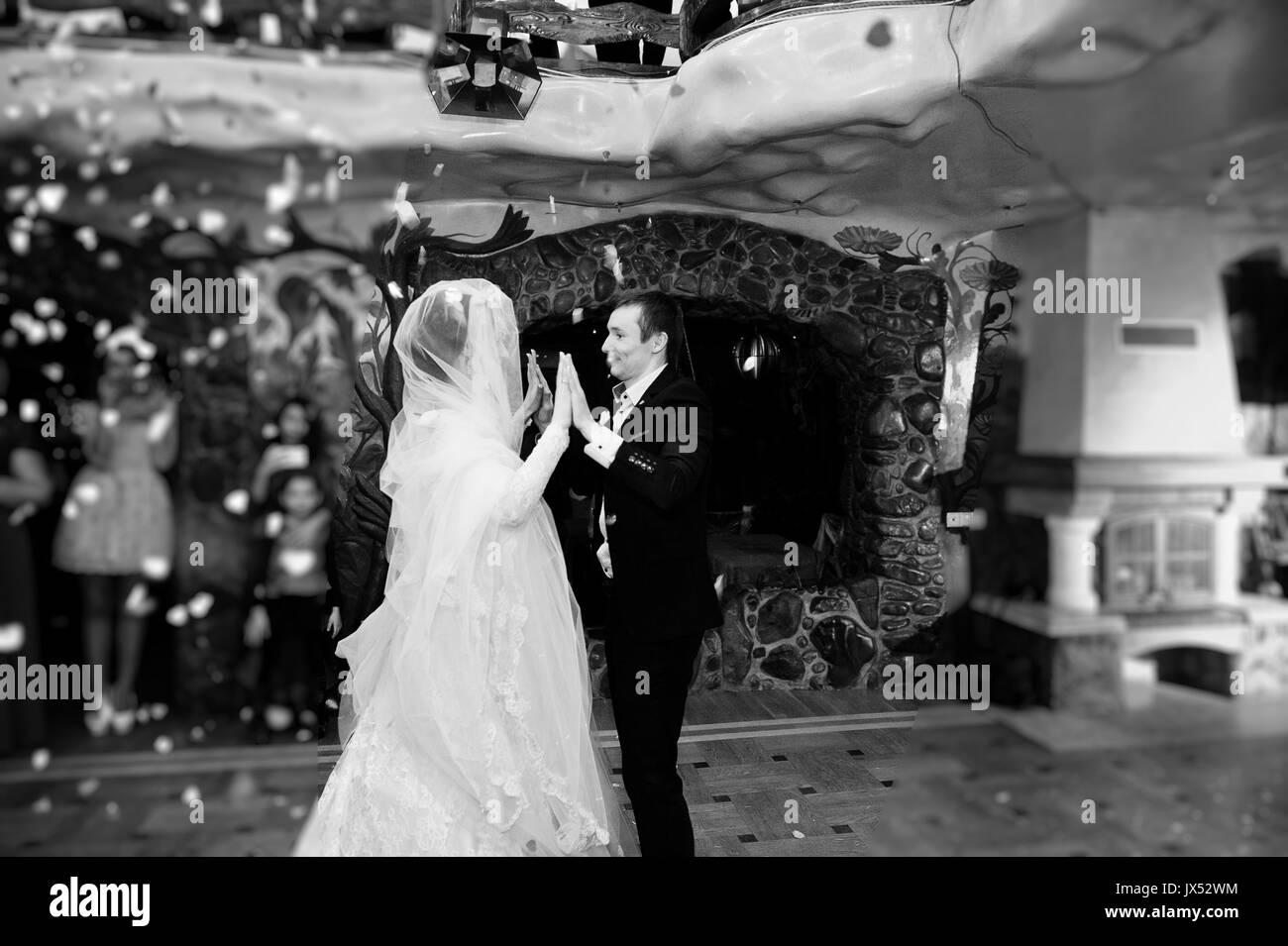 Hochzeit paar Tanzen ihren ersten Tanz im Restaurant mit Konfetti auf dem Boden. Schwarz-weiß Foto. Stockfoto