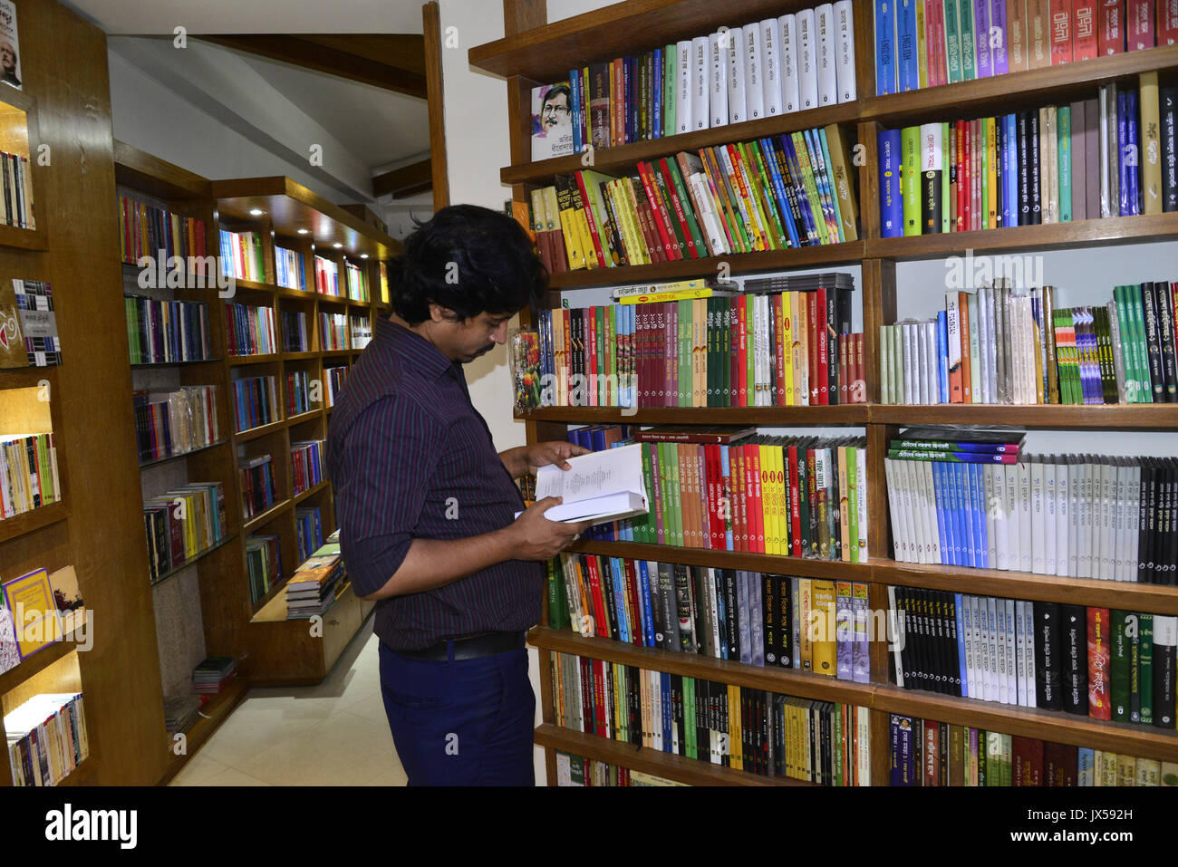 Dhaka, Bangladesch. 14 Aug, 2017. Ein Bangladeshi Leute liest und Suche Roman, historischen, Literatur und andere Bücher für kaufen in einer Buchhandlung in Dhaka, Bangladesch, am 14. August 2017 Credit: Mamunur Rashid/Alamy leben Nachrichten Stockfoto