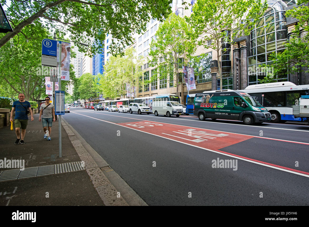 Sydney, Australien - Oktober 21, 2015: Die Menschen gehen auf die Straße in der Nähe von St. James Bahnhof Bushaltestelle und generische Sicht der östlichen Vorort Street in Sydney Stockfoto