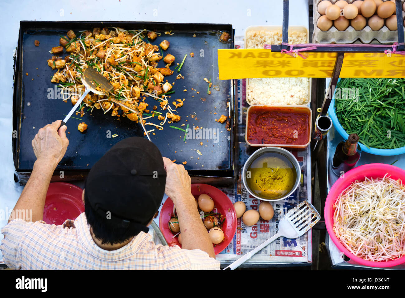 Kota Kinabalu, Malaysia - 1. August 2017: Blick von oben auf die nicht identifizierten Mann kochen einem gebratenen Rettich Kohlrabi mit Gemüse in der Food Street stall in Kota Stockfoto