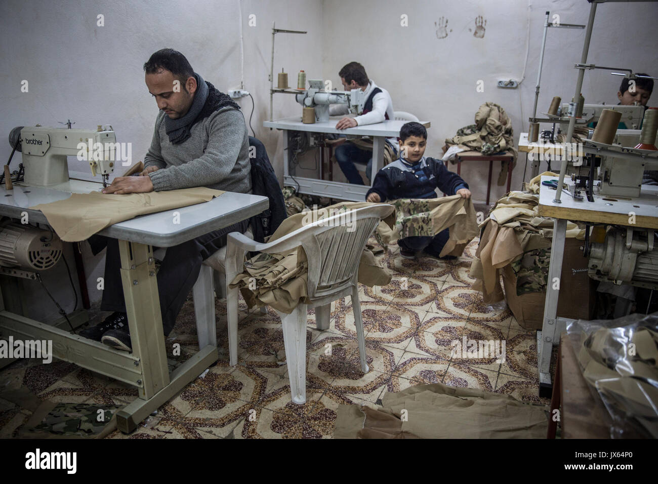 Einer der unzähligen Zahl syrischer Flüchtlinge Kinder in Fabriken in der Türkei arbeiten, jetzt nach Hause zu über 2,7 Millionen Syrer. Die kleine Textil shop, wo er und andere Jungen, Mädchen und Männer beschäftigt sind produziert Uniformen und Rucksäcke, die an den verschiedenen kriegführenden Parteien in Syrien verkauft werden. Die Armut treibt viele Familien ihre Kinder zur Arbeit anstatt zur Schule. Bildungschancen für die Syrer in der Türkei sind auch begrenzt. Stockfoto