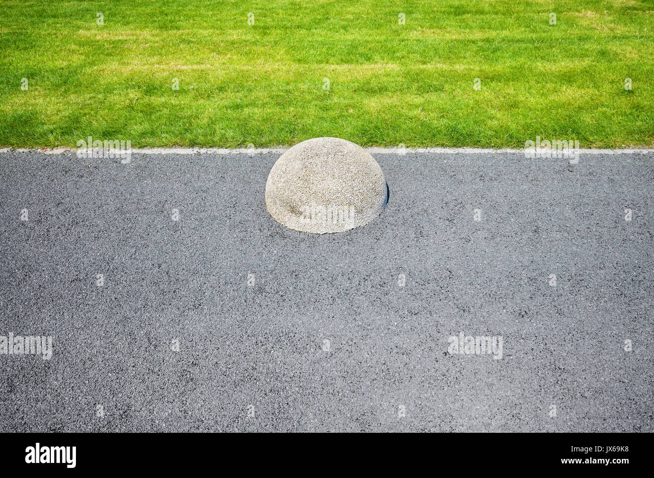 Zusammenfassung Hintergrund aus Asphalt, Rasen und Hemisphäre Barriere. Stockfoto