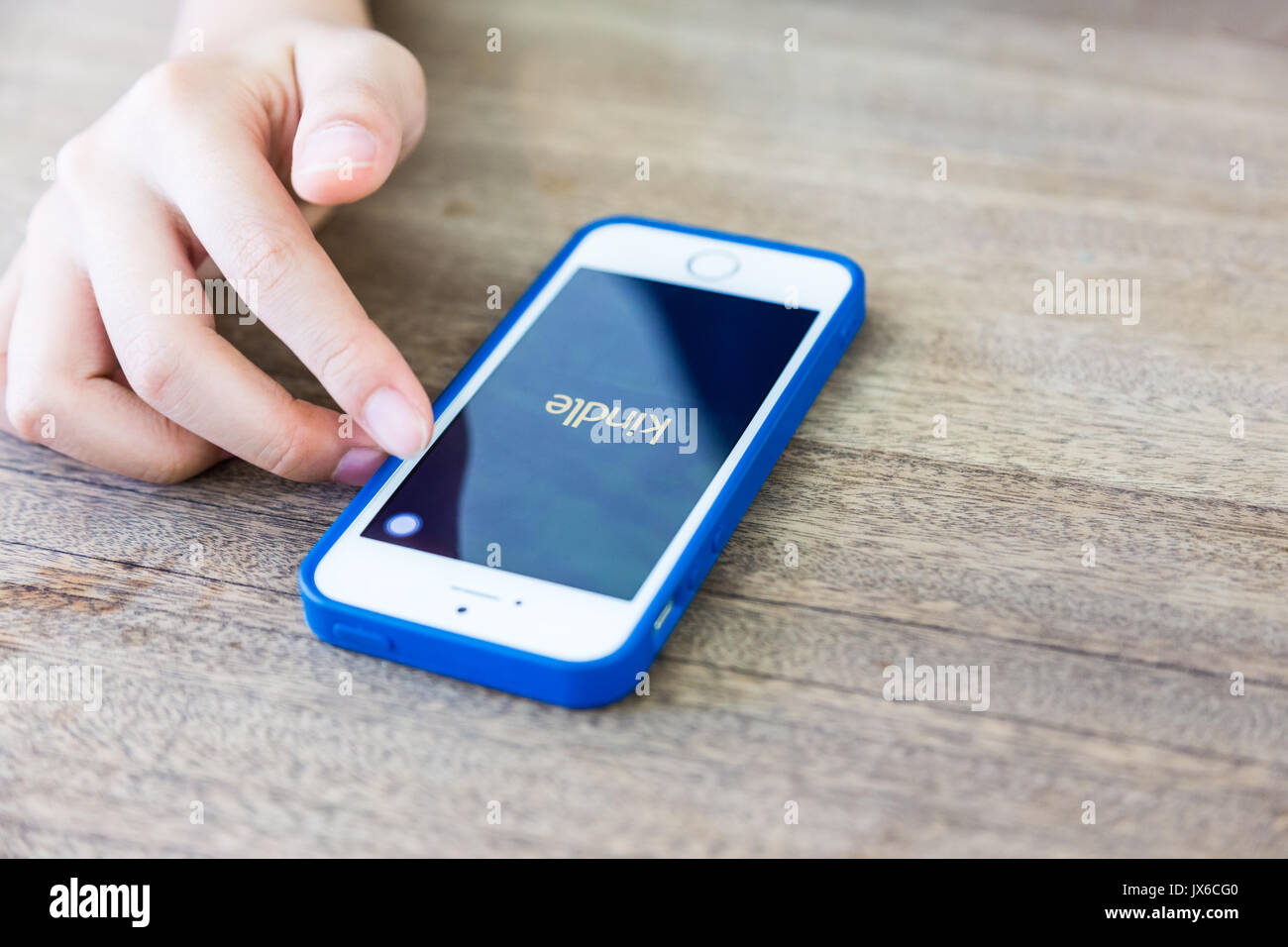 Bangkok, Thailand - 12. August 2017 - weibliche Hand nutzt Apple iPhone Amazon Kindle App zu ebooks in Bangkok, Thailand Am 12. August lesen Sie starten, 2017 Stockfoto