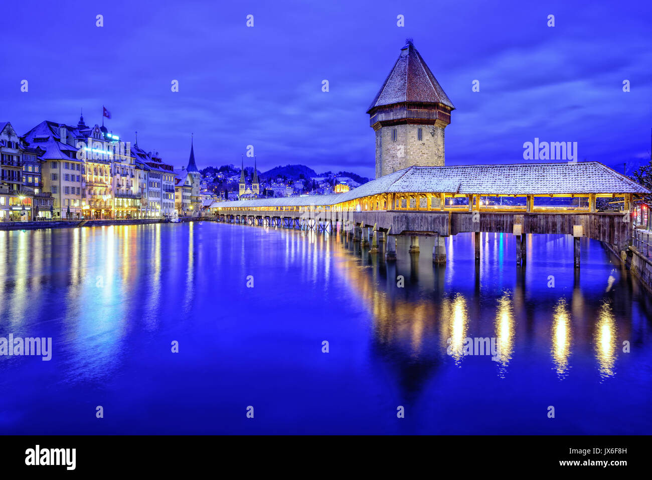 Altstadt von Luzern, Schweiz, mit hölzernen Kapellbrücke über die Reuss, der Wasserturm und der Promenade auf einem blauen winter Abend Stockfoto