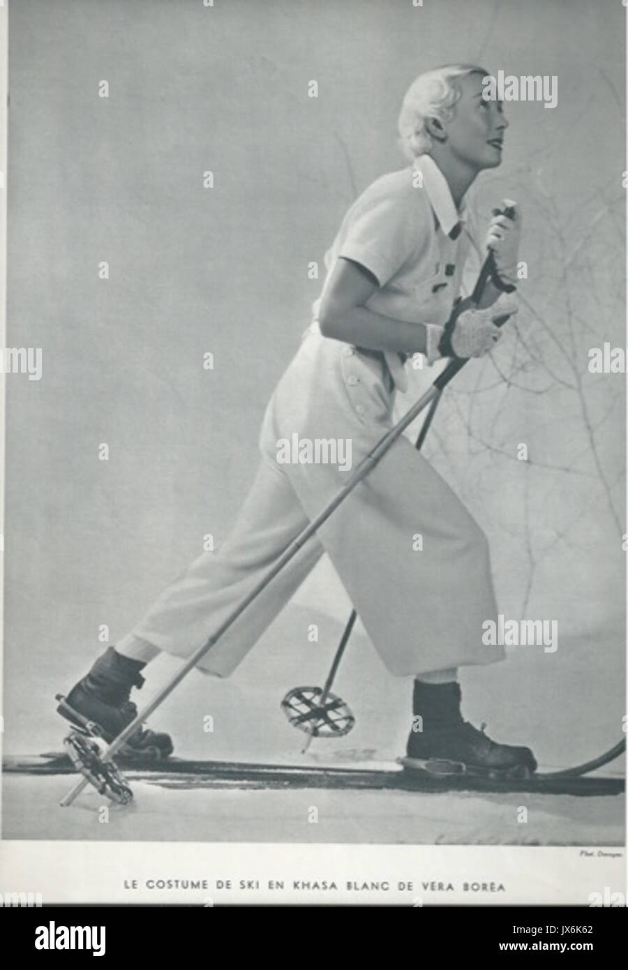 Dieses Foto aus dem Jahr 1934 zeigt ein weißes Skioutfit von Vera Borea, das das modische Design und die Entwicklung der Wintersportbekleidung im frühen 20. Jahrhundert demonstriert. Stockfoto