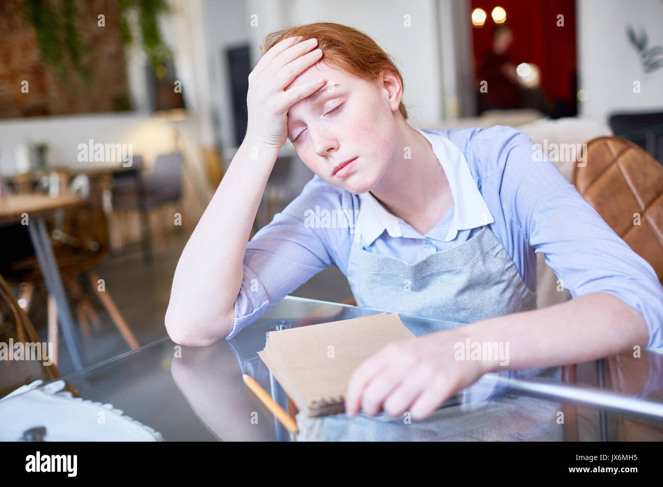 Erschöpft Kellnerin leiden unter Kopfschmerzen. Stockfoto