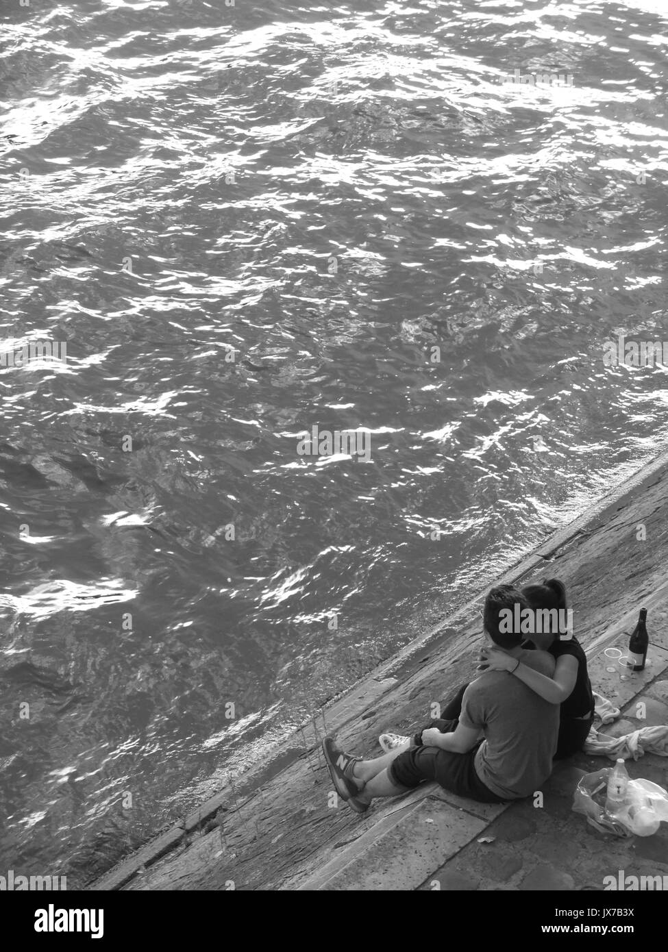 Zwei Liebende auf dem Ufer der Seine in Paris, Frankreich umfassen Stockfoto