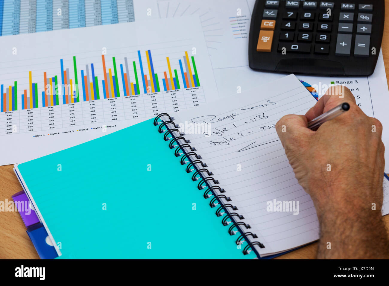 Acountant beschäftigt an seinem Schreibtisch in seinem Notebook und studieren Diagramme während der Berechnungen Stockfoto