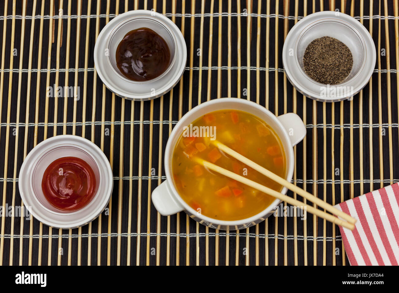 Schale, frisch zubereitete Suppe mit Stäbchen auf einem Bambus Matte mit einigen Seite dips servieren Stockfoto