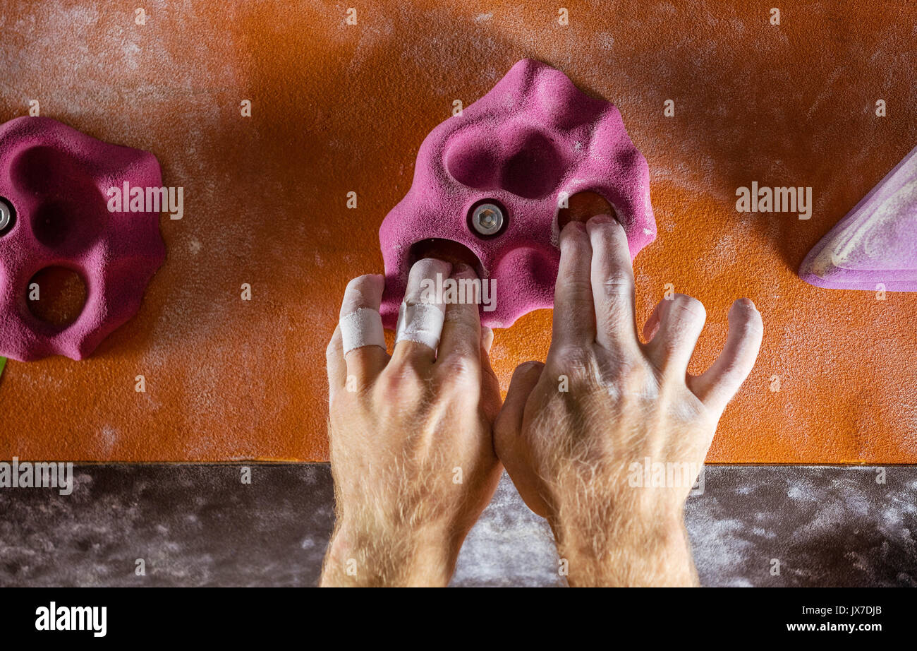 Nahaufnahme der Kletterer Hände greifen Haltegriff in der Kletterhalle Stockfoto