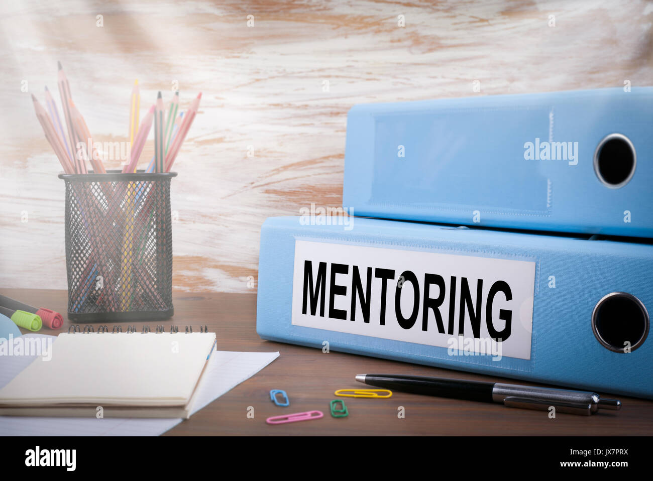 Mentoring, Büro Binder am Schreibtisch aus Holz. Auf dem Tisch Bleistifte, Kugelschreiber farbig, notebook Papier. Stockfoto