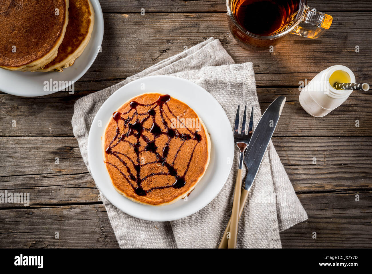 Ideen für Frühstück sind Halloween, Essen für Kinder. Pumpkin Pie Pfannkuchen mit Schokolade Sirup in einem traditionellen Stil dekoriert - Spinnennetz, Spinne, Stockfoto