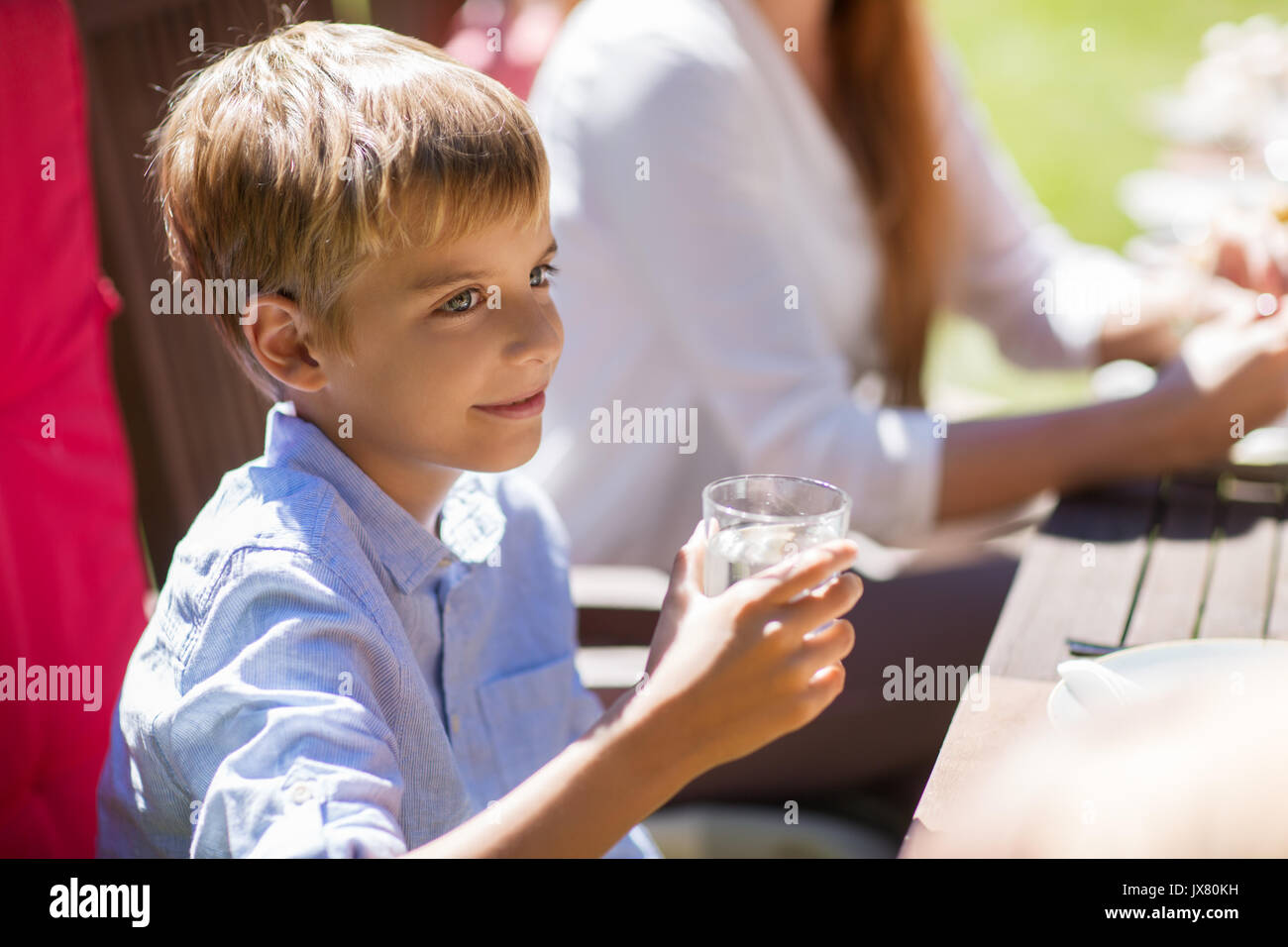 Happy Boy mit einem Glas Wasser zu festlichen Abendessen Stockfoto