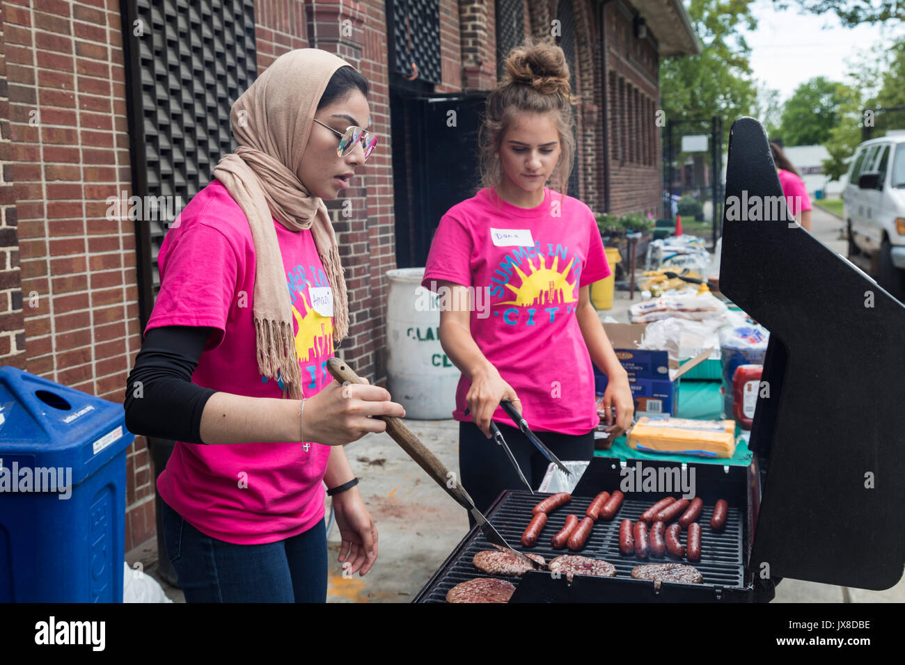 Detroit, Michigan - die Freiwilligen mit den Sommer in der Stadt Programm Grill Hot Dogs und Hamburger für die Kinder in der Clark Park. Stockfoto
