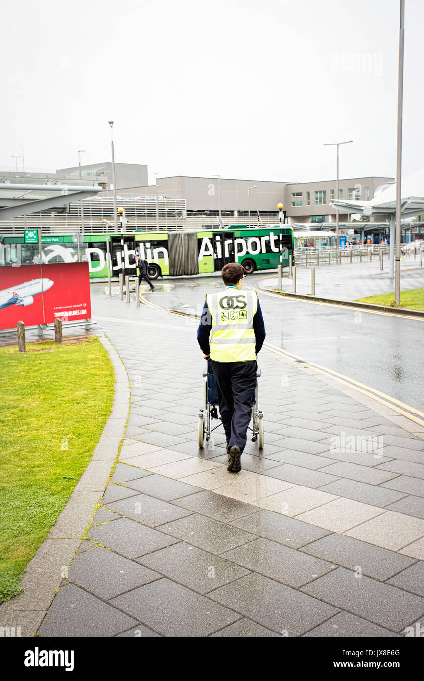 Dublin Airport, Passagiere, die mit Koffern auf walkway Escalator in Bewegung mit markierten Bilder von Irland im Hintergrund, Dubli Stockfoto