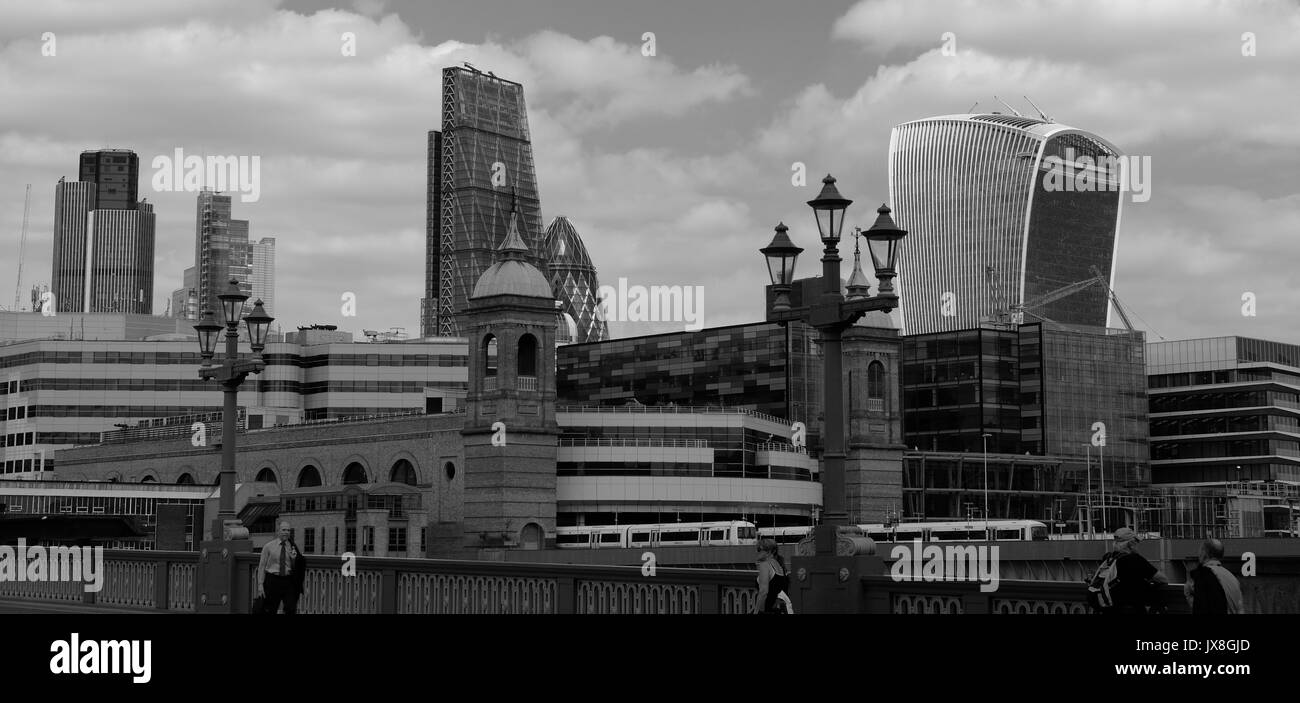 Die Aussicht von Southwark Bridge zeigt einen Zug, Cannon Street Station, und die Londoner Wolkenkratzer in den Hintergrund. Stockfoto