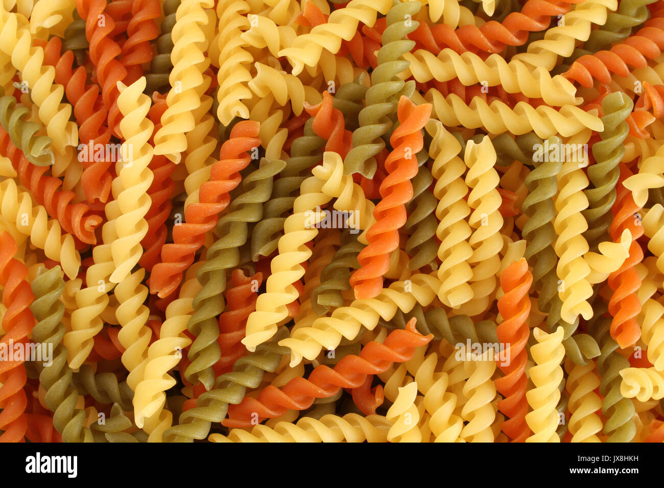 Essen-Hintergrund - dreifarbige Fusilli Hartweizen Weizen Teigwaren mit Spinat und Tomaten Stockfoto