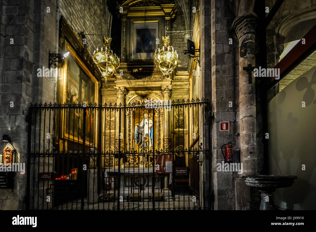Kleine, dunkle gotische Altar in einer Kirche in Rom mit Kerzen beleuchtet und eine Statue der Jungfrau Maria Stockfoto