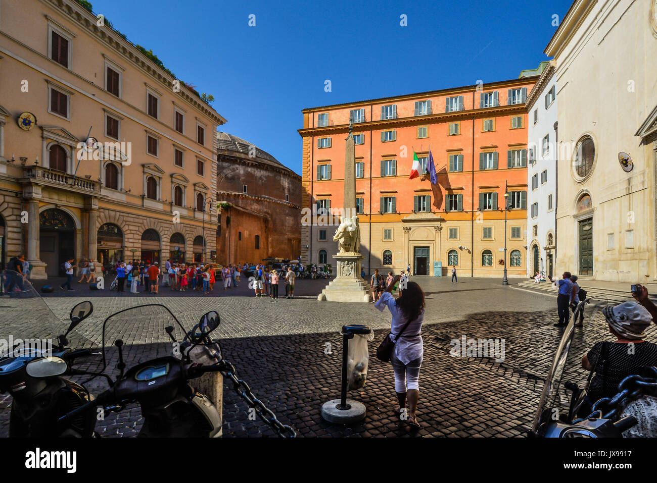 Sonnigen Tag in Piazza Della Minerva wie die Rückseite des Pantheon Webstühle im Hintergrund. Touristen und eine junge Dame Foto der Elefant obelisk Stockfoto