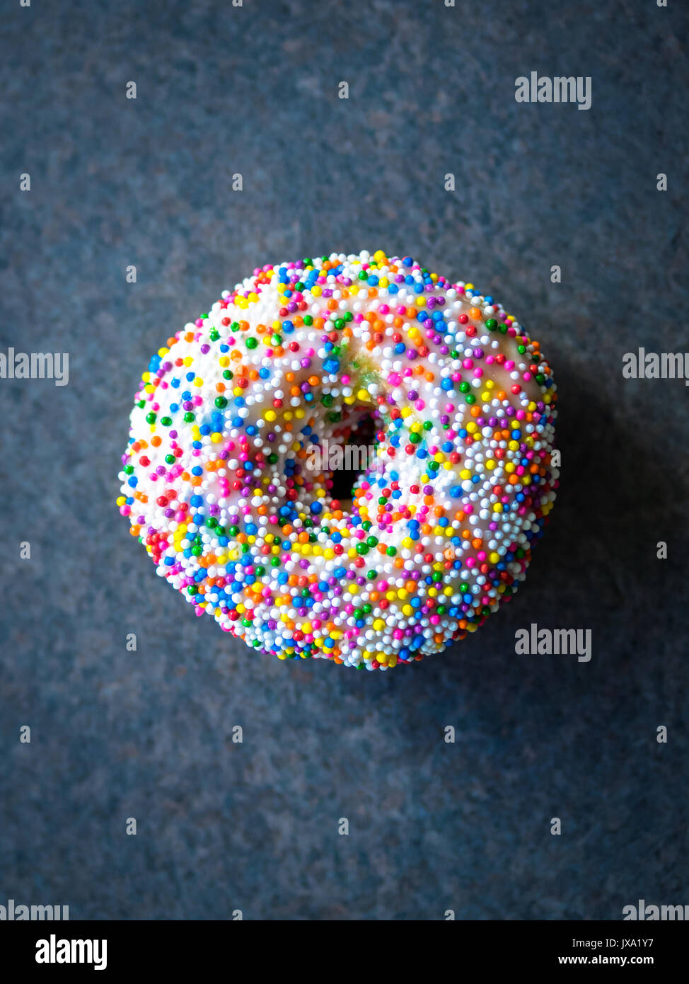 Ein vanilla dip-donut Donut (bestreuen, Rainbow streuen Donut) von Tim Hortons, einem beliebten Kanadischen fast food Restaurant und Donut Shop. Stockfoto