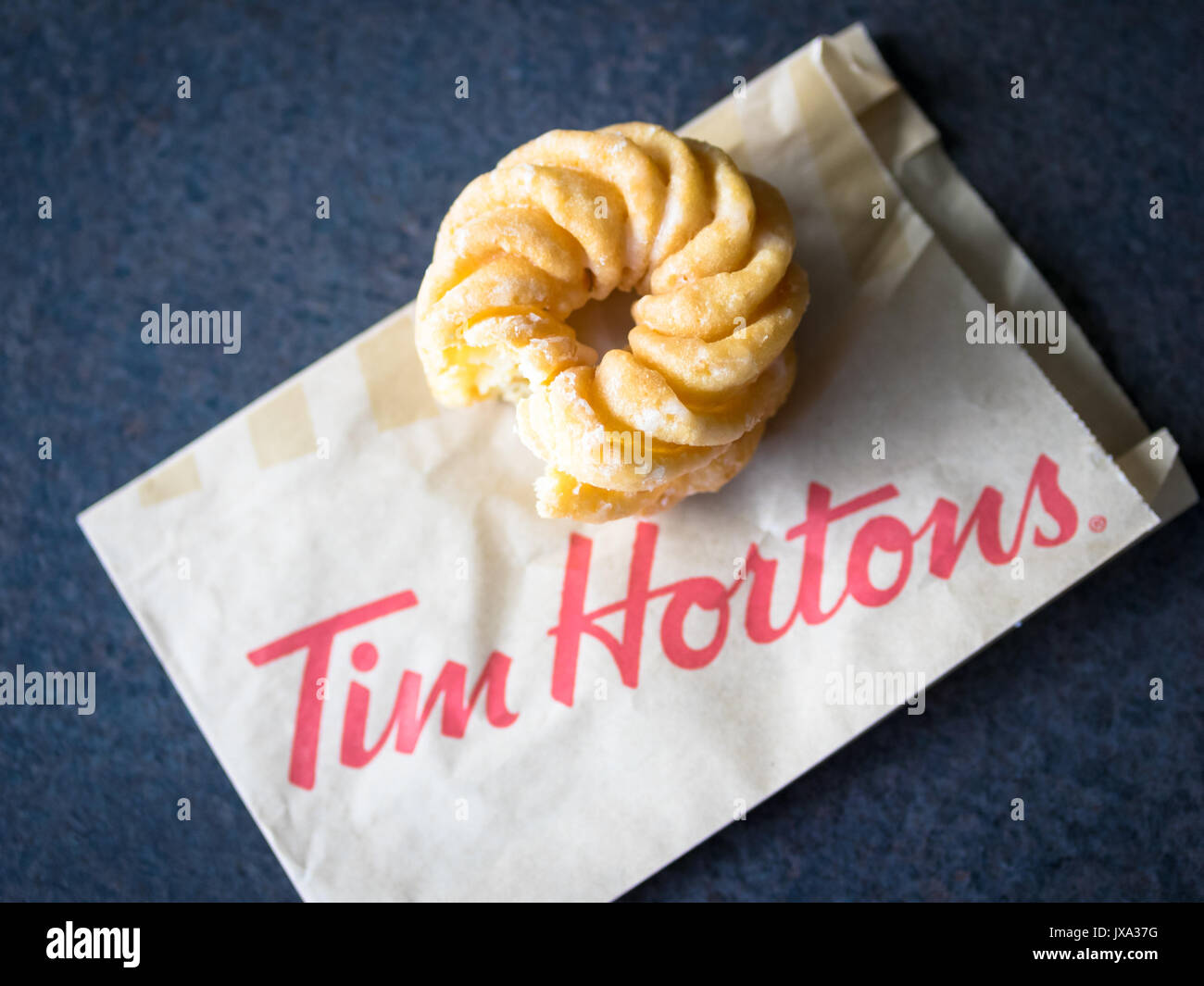 Ein Honig cruller Donut von Tim Hortons, einem beliebten Kanadischen fast food Restaurant und Donut Shop. Stockfoto