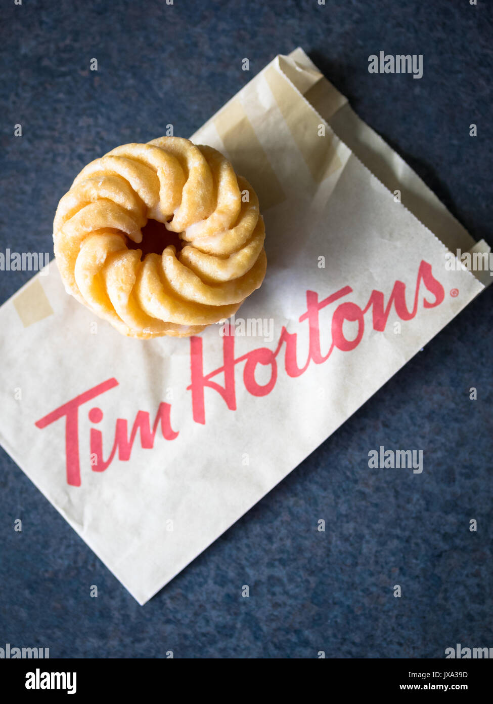 Ein Honig cruller Donut von Tim Hortons, einem beliebten Kanadischen fast food Restaurant und Donut Shop. Stockfoto