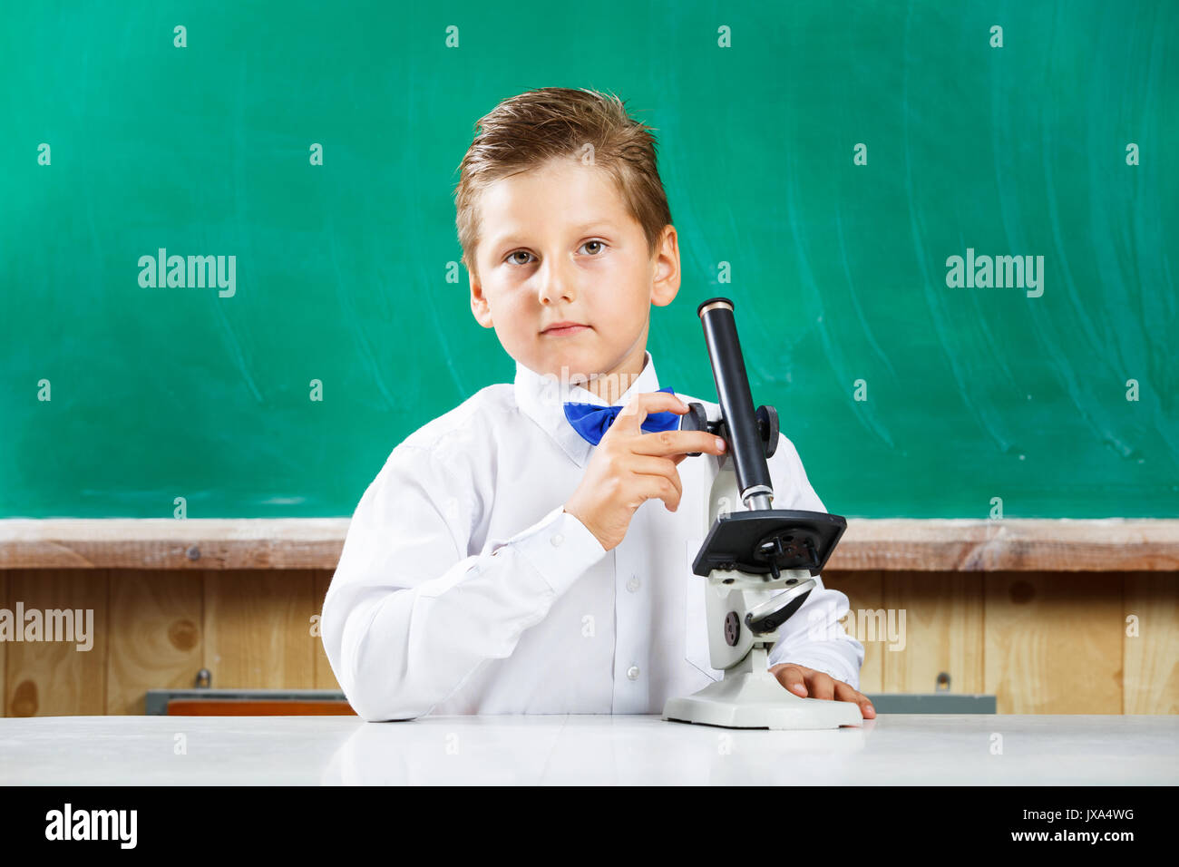 Smart stilvolle Schüler verwendet Mikroskop auf Lektion. Wenig Kursteilnehmer in der Schule Stockfoto