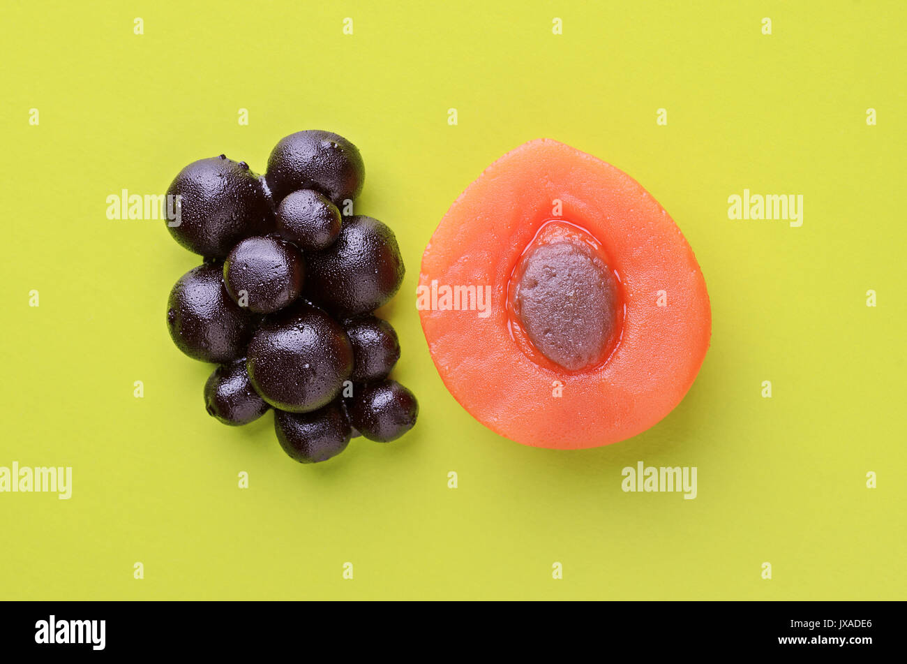 Aprikose und Beeren süße Marmelade candy auf blauem Hintergrund, Ansicht von oben. Trendy buntes Foto. Minimalistischer Stil mit bunten Papier Kulisse. Flach fa Stockfoto