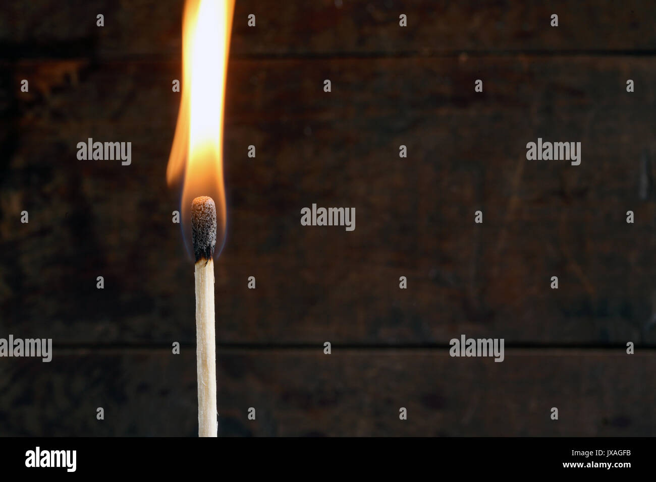 Nahaufnahme von einem brennenden Streichholz auf dunklem Hintergrund Stockfoto