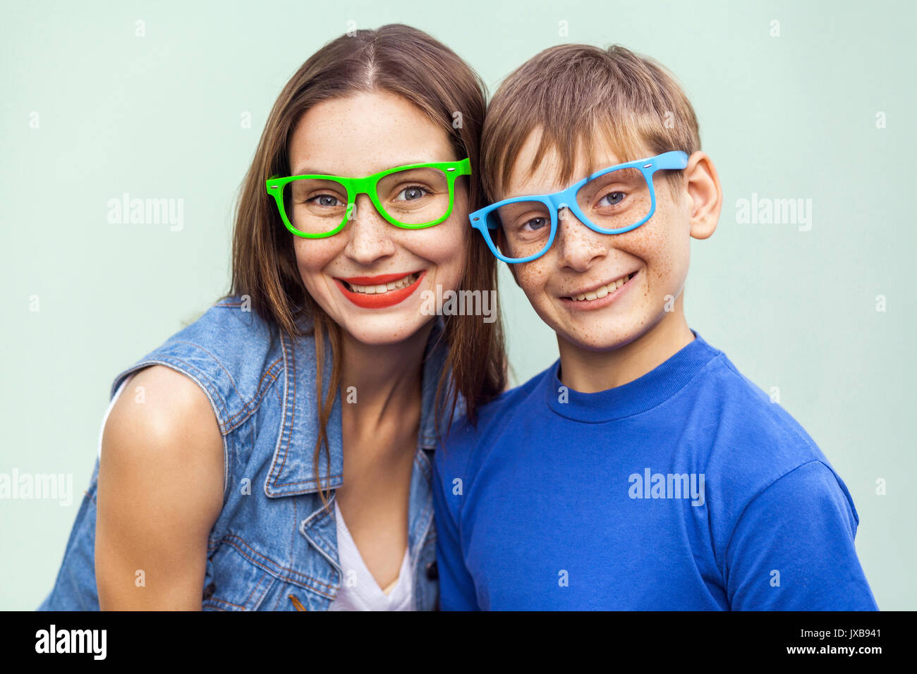 Brillen Konzept. Hipster Style. Portrait von wunderschönen sommersprossige Bruder und Schwester in Casual T-Shirts tragen trendige Brillen und über Hellblau posing Stockfoto