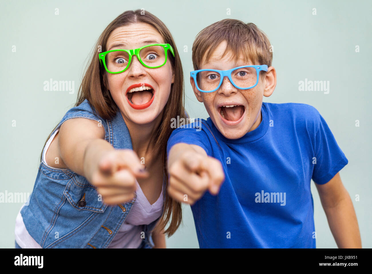 Gute Emotionen und Gefühle. Ältere Schwester und ihrem Bruder mit Sommersprossen, über hellblauen Hintergrund zusammen stellen, von der Kamera suchen mit Fi Stockfoto