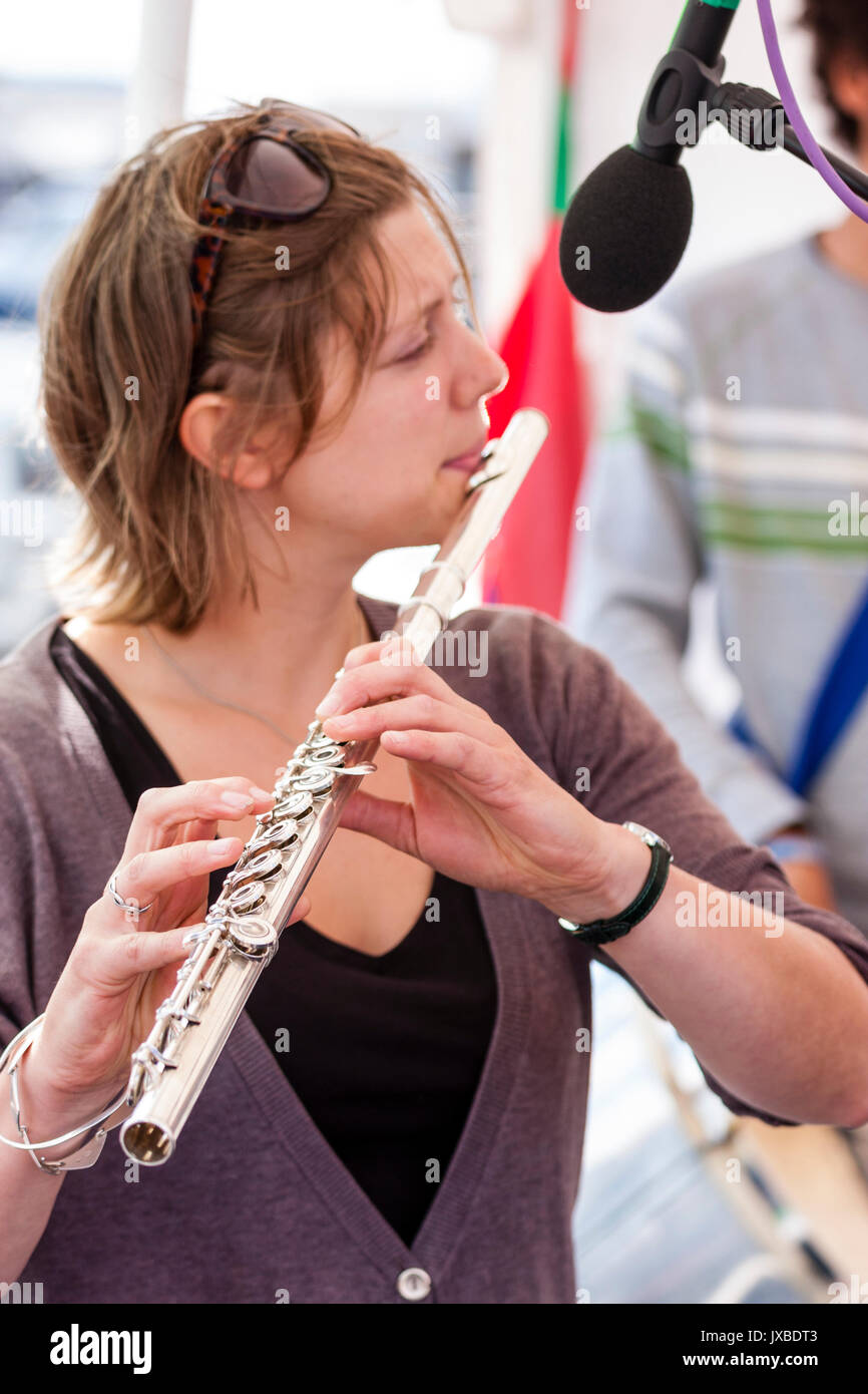 Kurze behaarte kaukasische Frau, 20s, Flöte zu spielen. Seitenansicht, bis zu schließen. Mitglied der Jazz Band Gator Hund Schnapper. Stockfoto