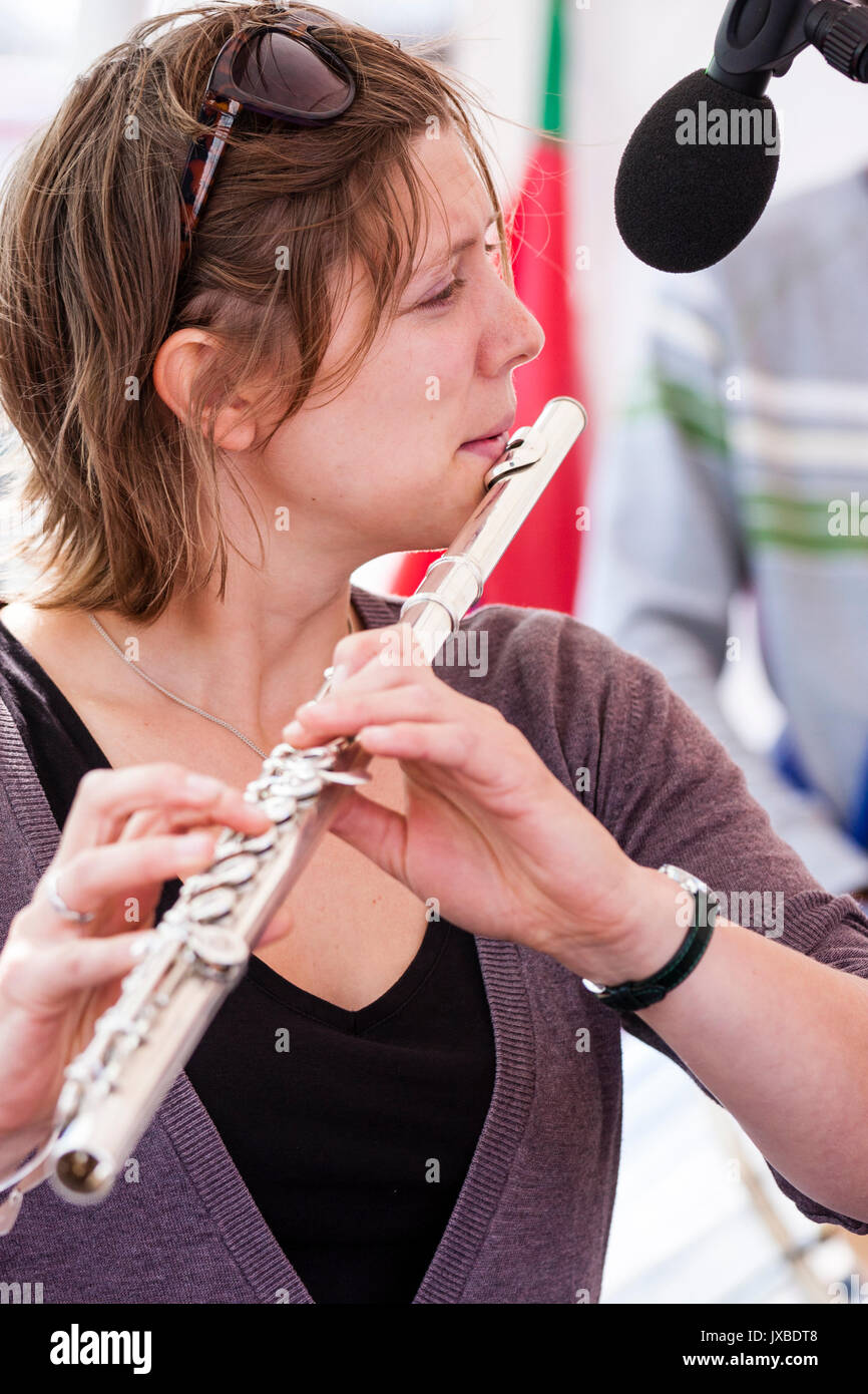 Kurze behaarte kaukasische Frau, 20s, Flöte zu spielen. Seitenansicht, bis zu schließen. Mitglied der Jazz Band Gator Hund Schnapper. Stockfoto