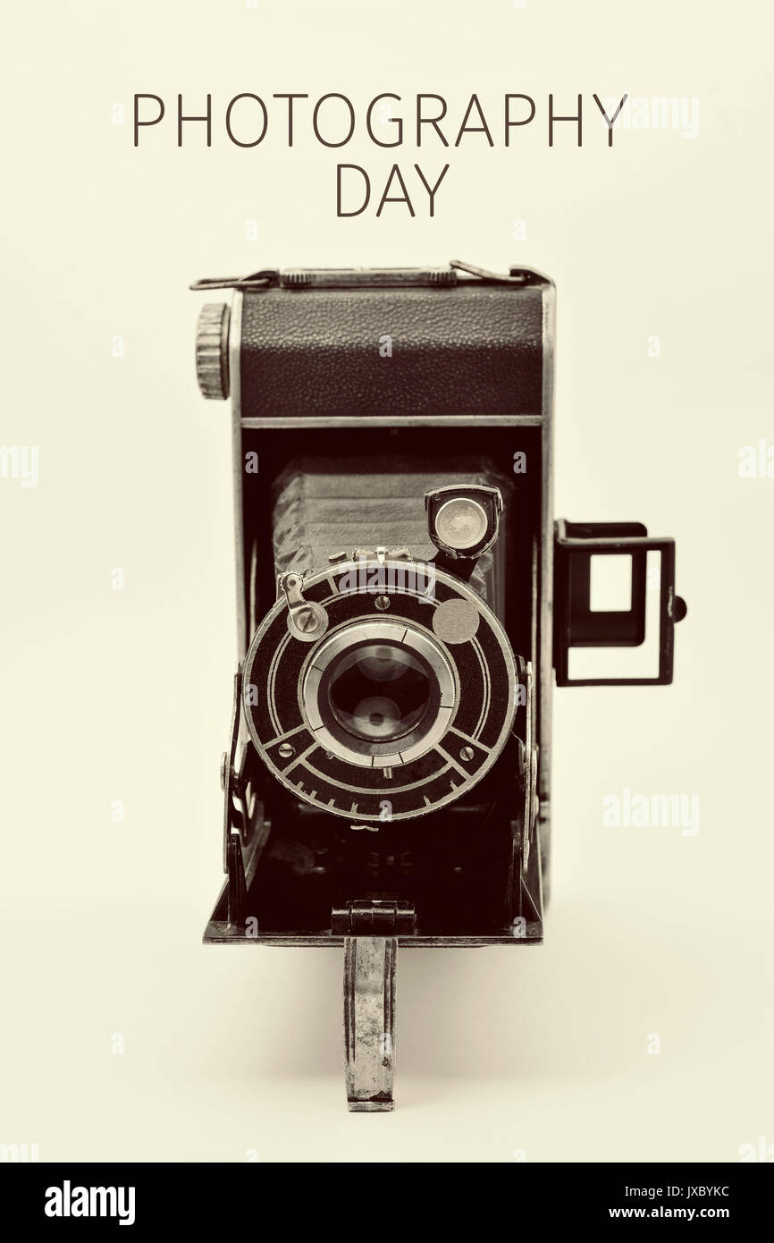 Eine alte Kamera und der Text fotografie Tag gegen einen weißen Hintergrund Stockfoto