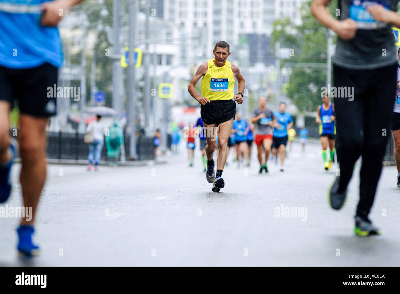 Alter Athlet Runner im Regen auf den Straßen der Stadt im Europa-asien-Marathon läuft Stockfoto