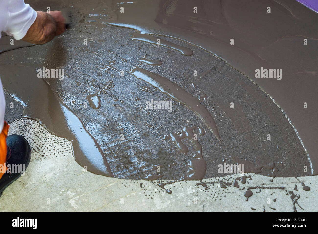 Arbeitnehmer setzt eine selbstnivellierende mit Werkzeug Estrich auf