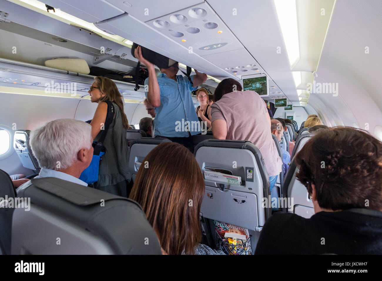 Passagiere, Condor, Thomas Cook Airlines, Flug, der Airbus A320-Verpflegung  in den Gang gehen zu ihren Sitz und das Setzen von Handgepäck in der  Dachkonsole Stockfotografie - Alamy