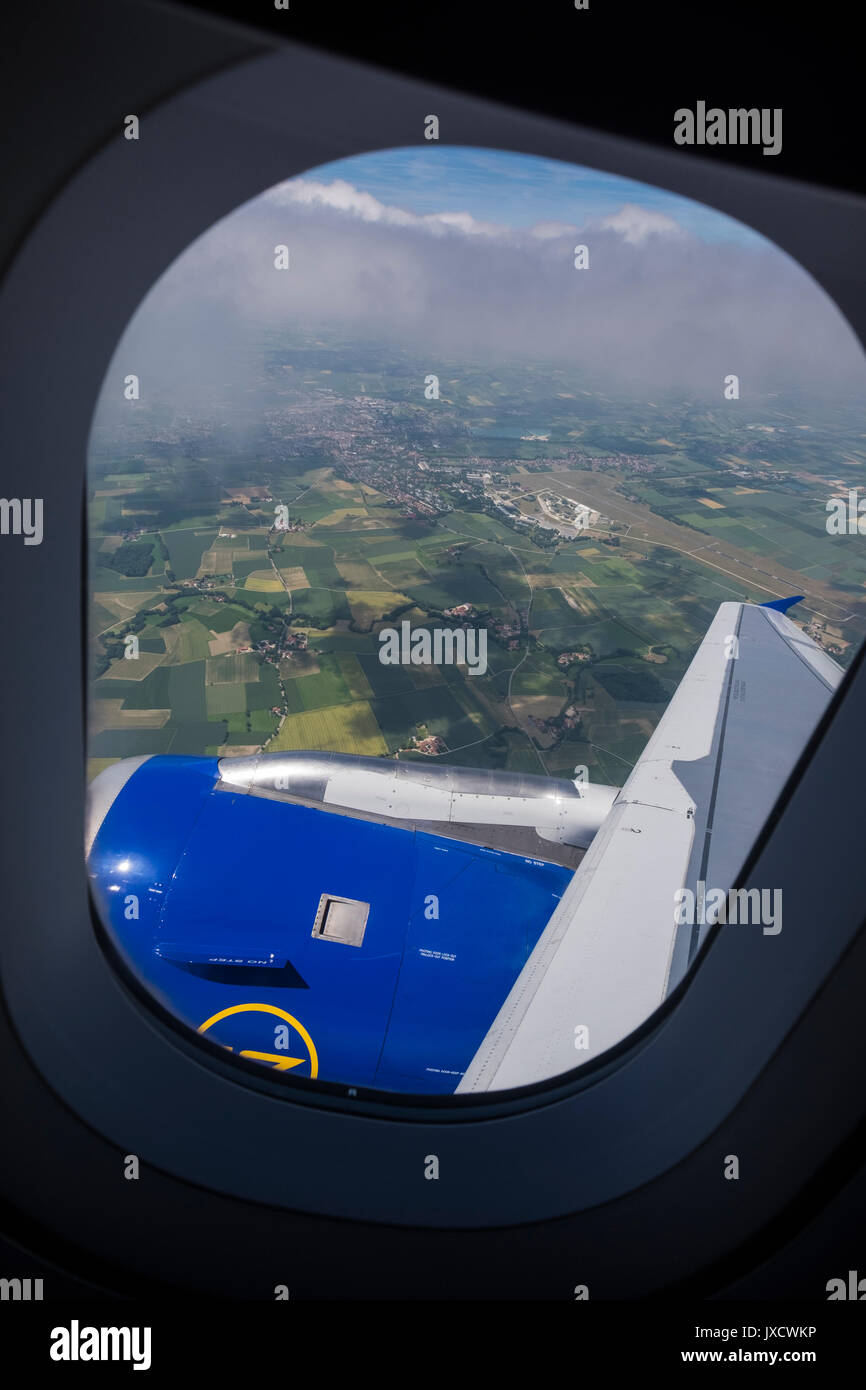 Auf grünes patchwork Felder durch ein Flugzeug bullauge Fenster kurz nach dem Start vom Flughafen München, Bayern, Deutschland Stockfoto