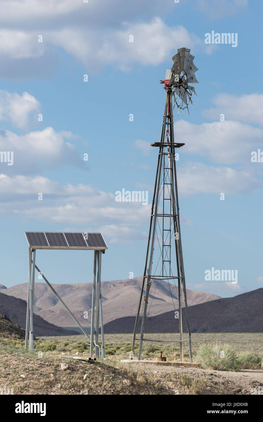 Solarpanel und Windmühle in der Wüste von Nevada. Stockfoto
