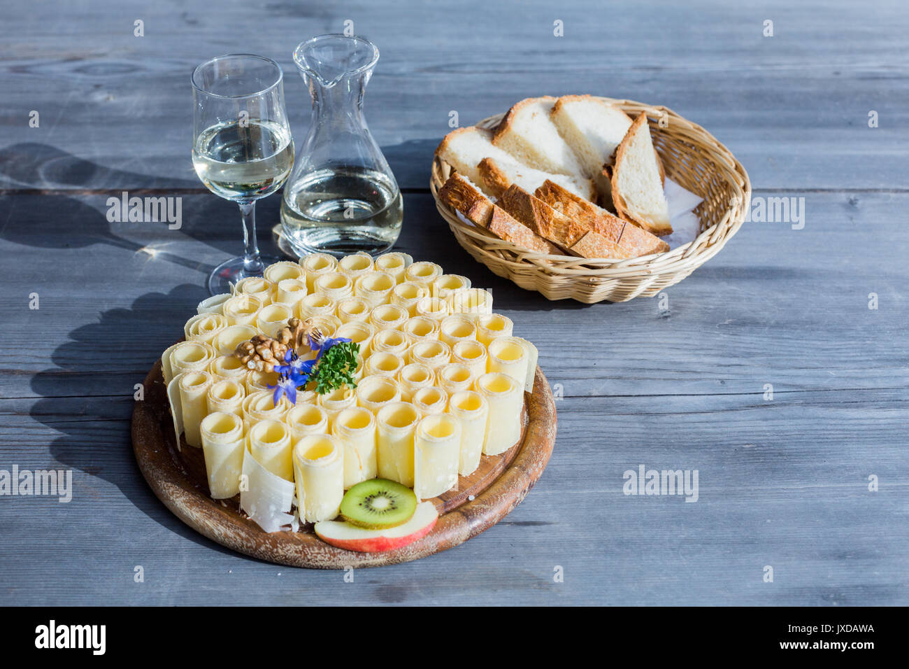Ein Tablett mit Käse Brötchen mit einem Krug Wein und einen Korb mit Brot  serviert. Diese Mahlzeit ist eine Schweizer Spezialität Stockfotografie -  Alamy