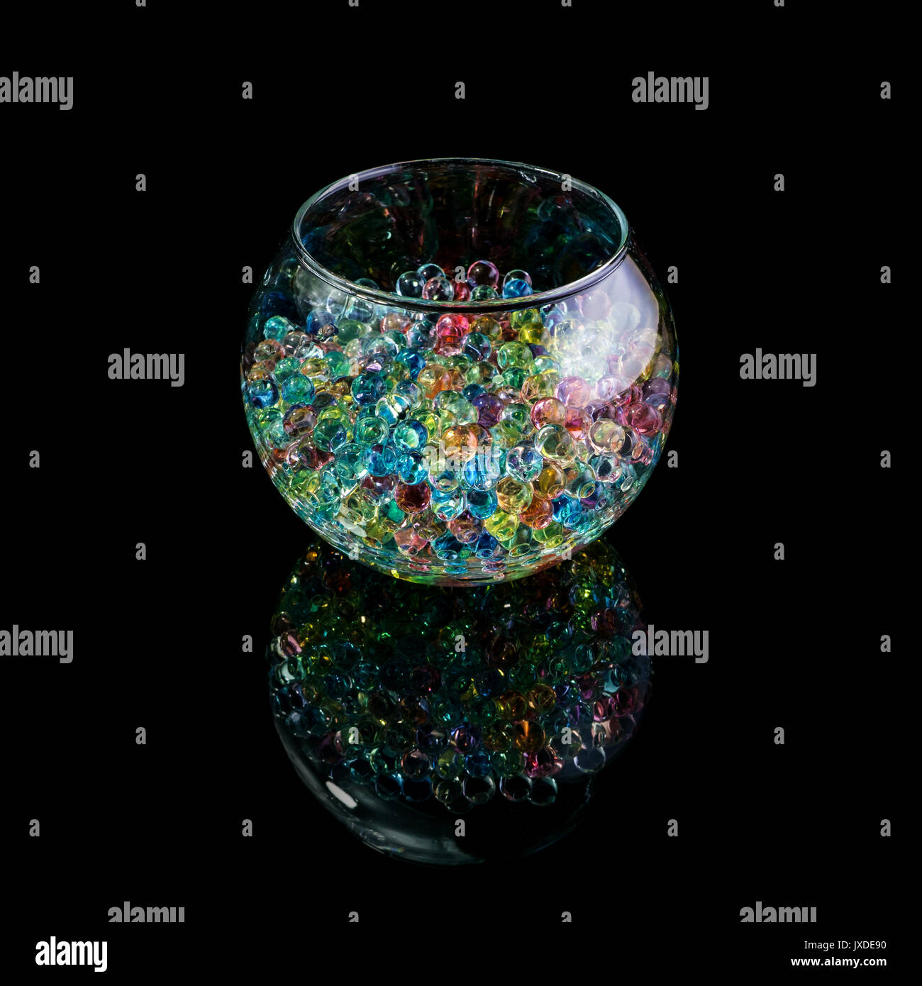 Farbige hydrogel Kugeln in einem Glas Vase auf einem schwarzen Hintergrund isoliert Stockfoto