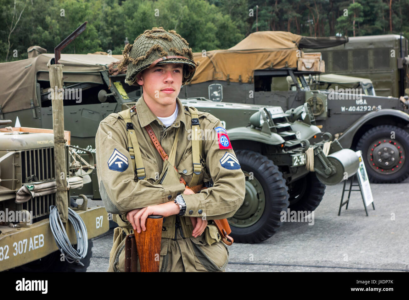 Junge re-Enactor posiert in WW2 US Airborne mit Techniker/5 Rang Abzeichen uniform vor der Amerikanischen Weltkrieg zwei Lkw auf militaria Messe Stockfoto