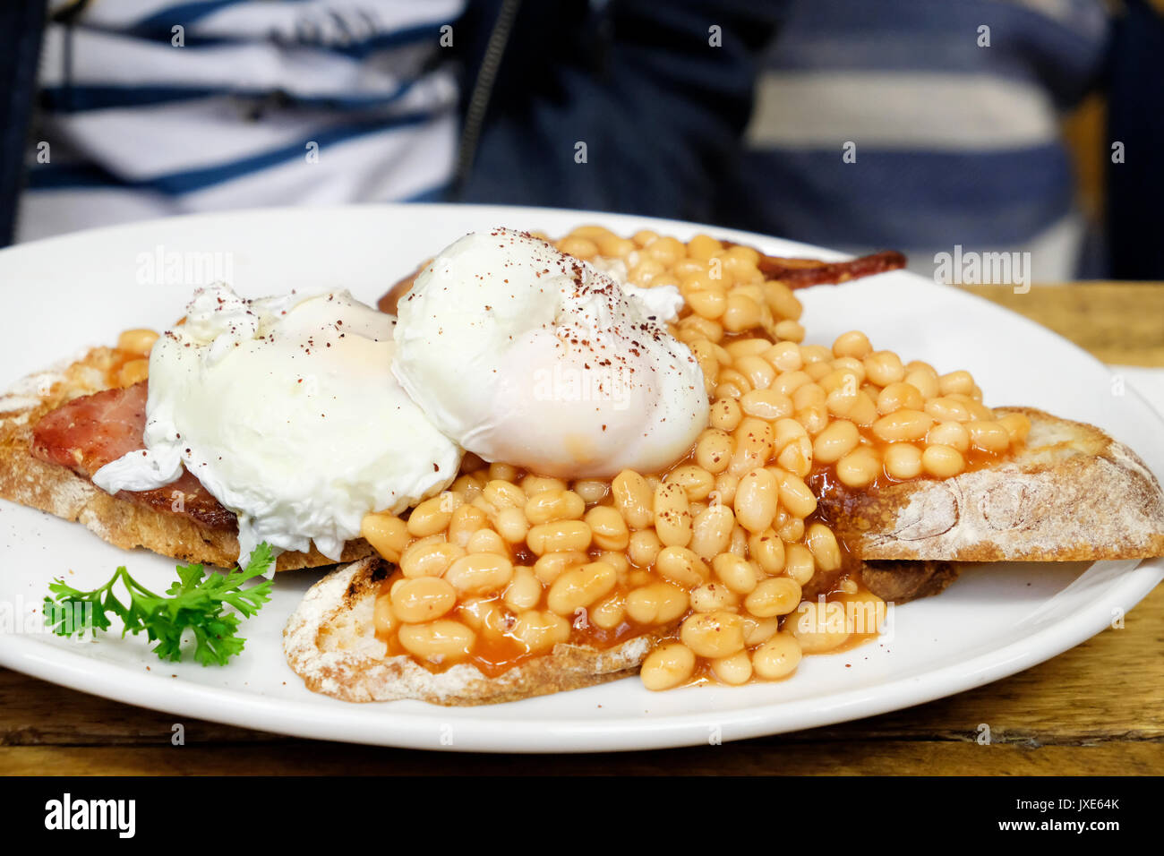 Eine gesunde Alternative zum herkömmlichen Englisches Frühstück mit pochierten Eiern, Tomaten, Wurst, Speck, Pilzen und Kale Stockfoto