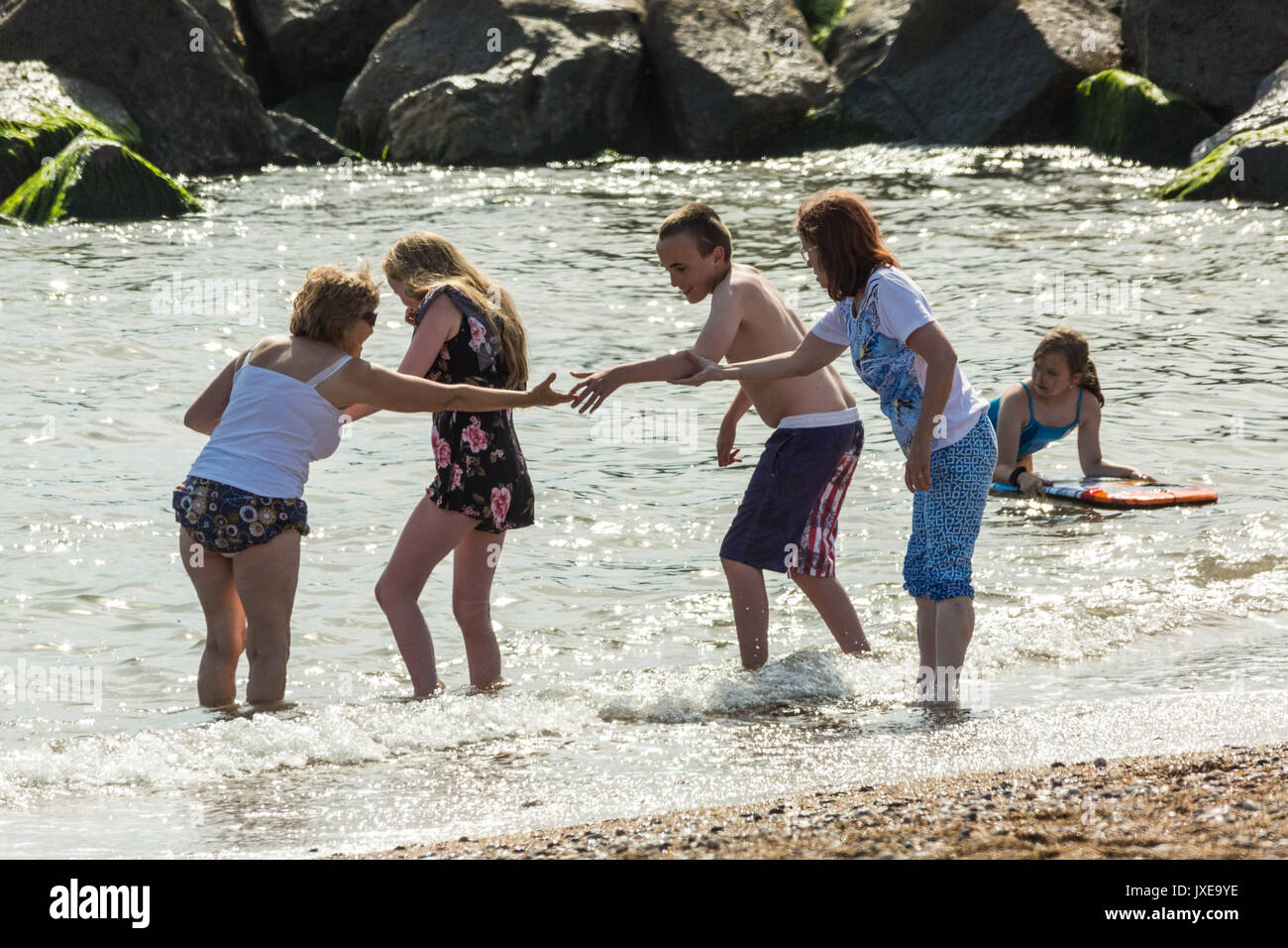 West Bay, Dorset, Großbritannien. 15 August, 2017. UK Wetter: Urlauber und Einheimische genießen Sie einen heißen sonnigen Nachmittag, Sonnenbaden und Schwimmen am Strand von West Bay. Foto Credit: Guy Corbishley/Alamy leben Nachrichten Stockfoto